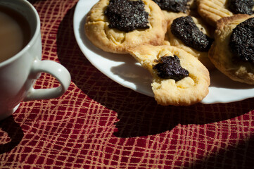 Cookies with poppy seed fillingand and coffee. Photo on a sunny day, daylight natural sunlight