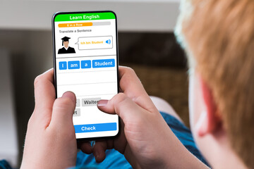 Boy Typing Text Message On Mobile Phone