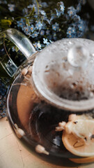 Glass teapot on a background of flowers.