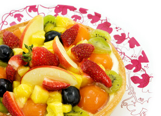 Fruit cake with various fruits and berries on the plate.