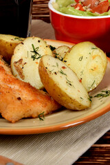small chicken chops with boiled potatoes and green lettuce with olives and sunflower seeds
