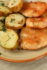 green lettuce with tomatoes and green olives next to fried potatoes and breaded cutlets