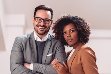 Portrait of business couple wearing suit and looking at camera