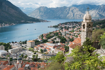 Fototapeta na wymiar Beautiful views of the city of Kotor and the Bay of Kotor. Church of Our Lady of Remedy. City in front and mountains in the back of the photo.