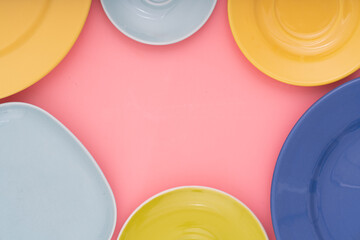 Color  dish plates on pink background flat lay