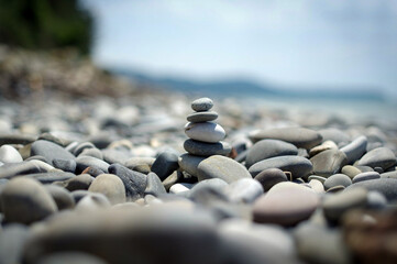 Fototapeta na wymiar Small stone cairn tower, poise stones, rock zen sculpture, light grey pebbles