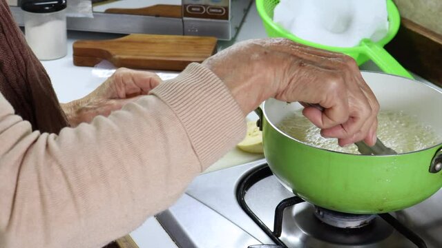 Deep frying pieces of plantain to make traditional patacones or tostones