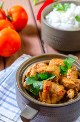 Fresh homemade chicken curry with chilly in vintage ceramic bowl. Selective focus.