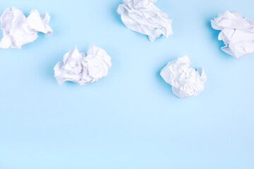 Crumpled white paper in the form of clouds on blue background. Concept head in clouds. Top view. Copy space