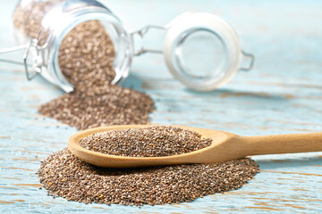 chia seeds in a wooden bowl on a blue wooden background, with copy space.