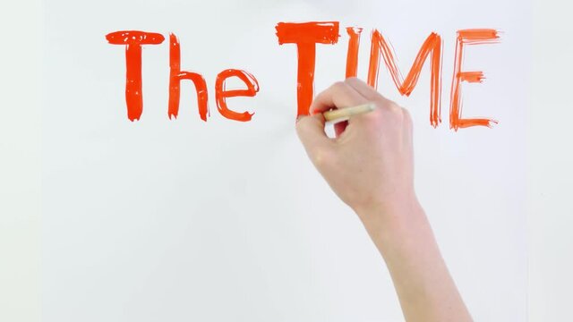 timelapse. close-up, hand writes slogan - The Time is now - with brush, using red paint on white banner, poster. Fighting against racism, for equal rights in USA.