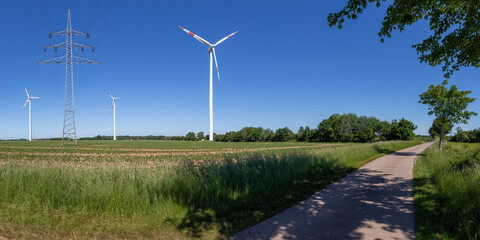 wind turbines and power line in agricultural Environment on a sunny summer day