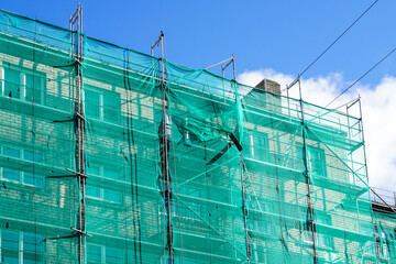 green safety net on scaffolding at the facade of an apartment house