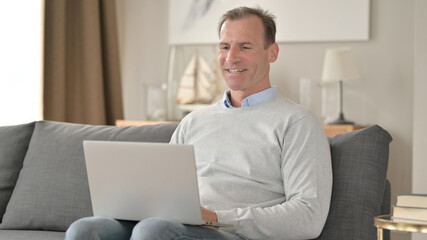 Middle Aged Businessman Talking during Video Chat on Laptop