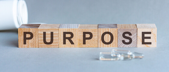 PURPOSE text on wooden table for your desing, coronavirus concept top view. Grey background.