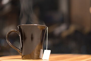 Black cup of hot tea with steam
