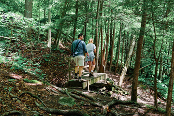 A hiking family  in McConnells Mill State Park, Pennsylvania, USA  in the summer during the COVID-19 quarantine  - obrazy, fototapety, plakaty