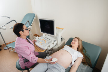 A pregnant girl gets an ultrasound of her abdomen at the clinic. Medical examination