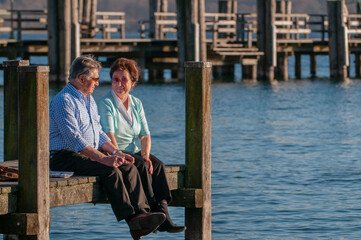 Happy senior couple sitting at the waterfront