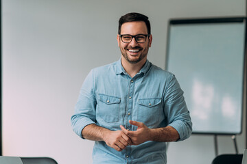 Portrait of happy young businessman at his office