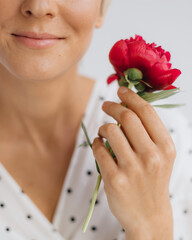 Beautiful blonde with a peony enjoys a moment at home