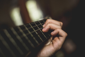 Close up of the guitar, when the man playing song and pressing the chords. 