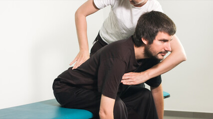 Fototapeta na wymiar Physiotherapist exercising with disabled person on a therapy table.