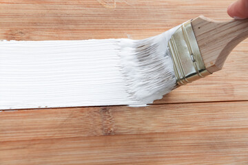 Repairs. wooden plank coating with paint. Toning. Painting wooden products. Do-it-yourself whitewashing. Paint with a brush in white. White enamel, water-based paint.