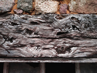 Wooden top beam with burls of an old window in France