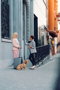 Two business female colleagues talking in front of hotel