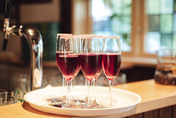 Several glasses of red drink standing on tray at bar. Celebration, birthday, party, wedding concept.