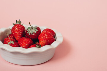 Fresh ripe delicious strawberries in a  bowl on a white background. Summer concept. 