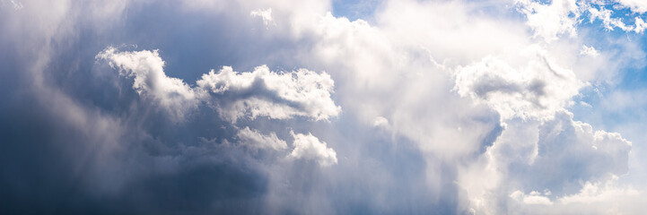 Wide sky panorama with scattered cumulus clouds bilding up before storm.