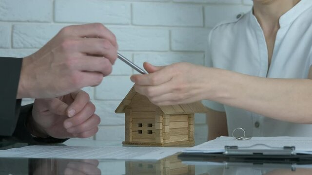 Contract for the purchase of a house. A man signs a contract with a realtor.