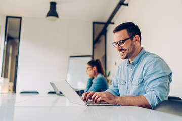 Happy businessman using laptop in the conference room