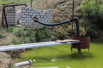 Homemade pump station in a pond for watering the garden