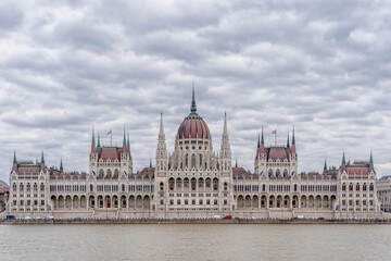 Obraz premium Hungarian Parliament facing Danube with clouds overhead in Budapest winter morning