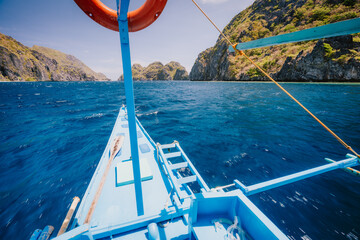 El Nido, Philippines. Island hopping Tour boat hover over open strait between exotic karst...