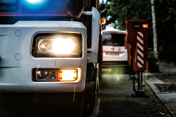 Frontbeleuchtung eines Feuerwehrautos während eines Einsatzes bei Dämmerung mit Blaulicht,...