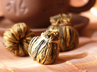 Tea Leaves with Poured Cup of Hot Drink. Aromatic flowers green chinese tea. Artwork. Flowers green chinese tea near ceramic cup