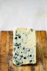 Wedge of blue cheese on a cutting board