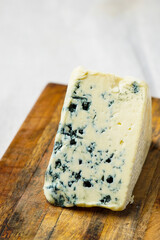 Wedge of blue cheese on a cutting board