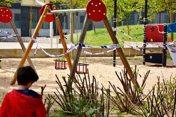 sad boy in front of a closed park