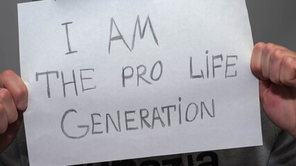 I am a pro life slogan.In a man's hands write,on a white background.