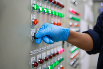 Technician hand operate switch and button of control panel