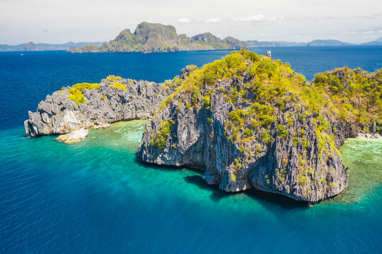 View from above, aerial view of unknown Island surrounded by turquoise, crystal clear sea. Bacuit Bay, El Nido, Palawan, Philippines