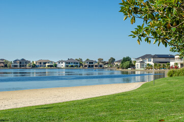 View of Sanctuary Lakes with some luxury waterfront houses in the distance.  - obrazy, fototapety, plakaty