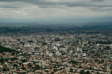 Aerial panorama view of the city Salta, in Argentina, at the foot of the mountains. Many concrete buildings in the valley under a cloudy sky