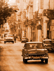 A classic car driving in a street in Havana. These old and classic cars are an iconic sight of the...