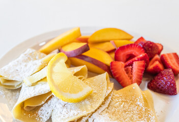 Crepes and Sliced Fruits on White Background